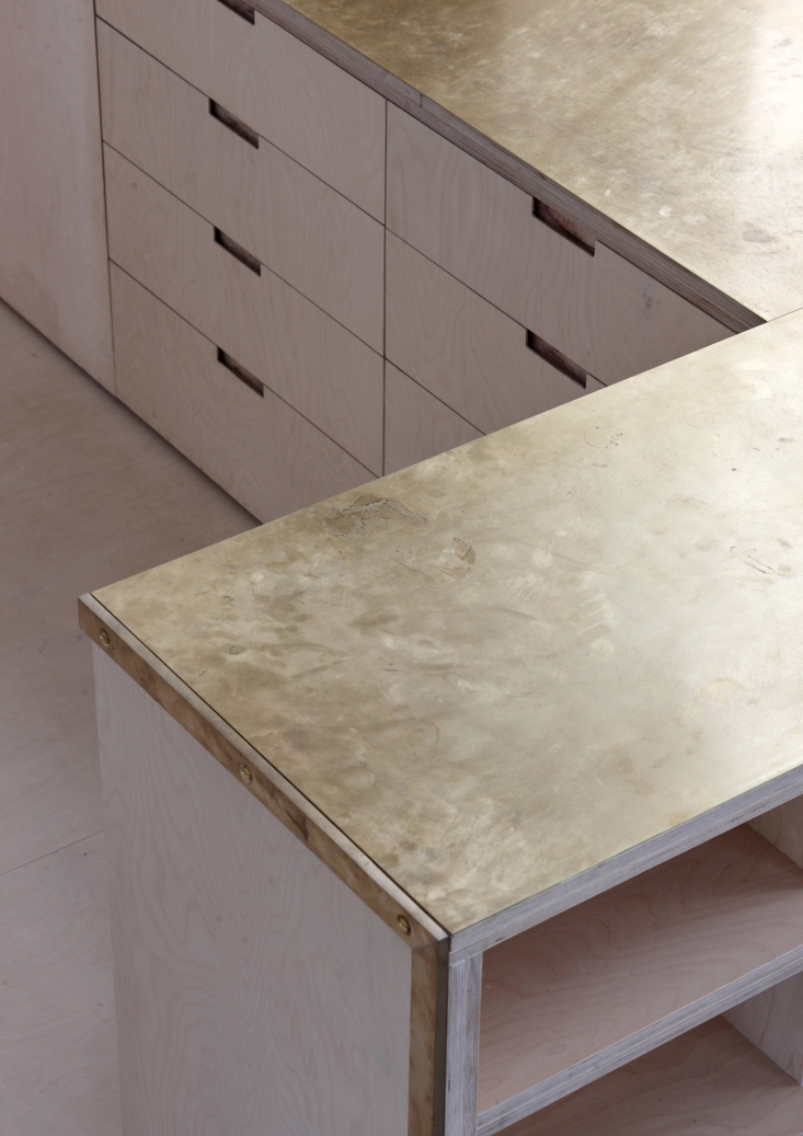 The counters (two layers of 18mm birch ply bonded with two millimeters of brass: total thickness 38 millimeters) are unlacquered and intended to gather fingerprints and patina over time. All millwork was designed by McLaren Excell and fabricated locally.