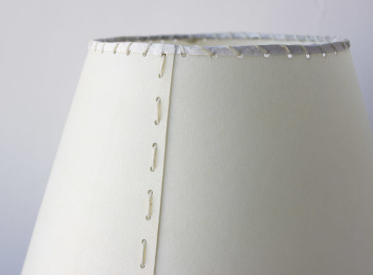The lampshade has a hand-stitched cream goatskin parchment shade and a hand-dyed braided cotton cord.